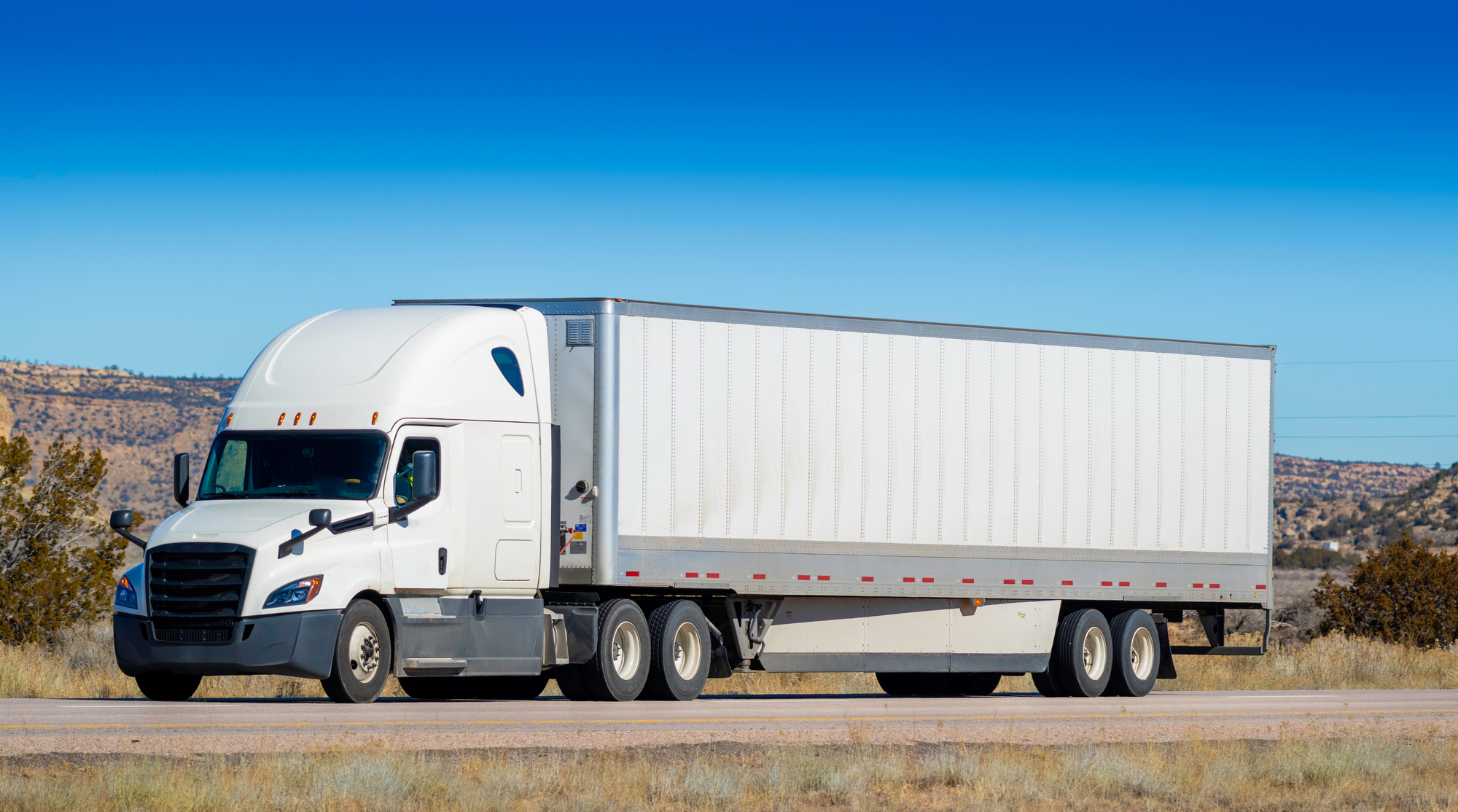 Truck Accident Avoidance Tips for Small Vehicles - Eighteen wheel big rig tractor with trailer on highway. Trucking industry